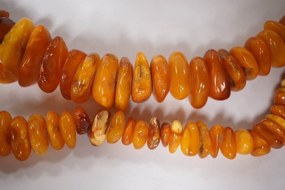 Three assorted amber necklaces including a single strand graduated oval bead necklace, 40cm, gross weight 37 grams, the other two necklaces gross weight 240 grams. Condition - poor to fair